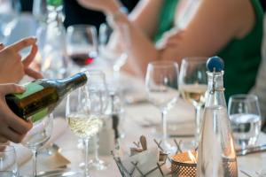 person pouring wine on clear wine glass